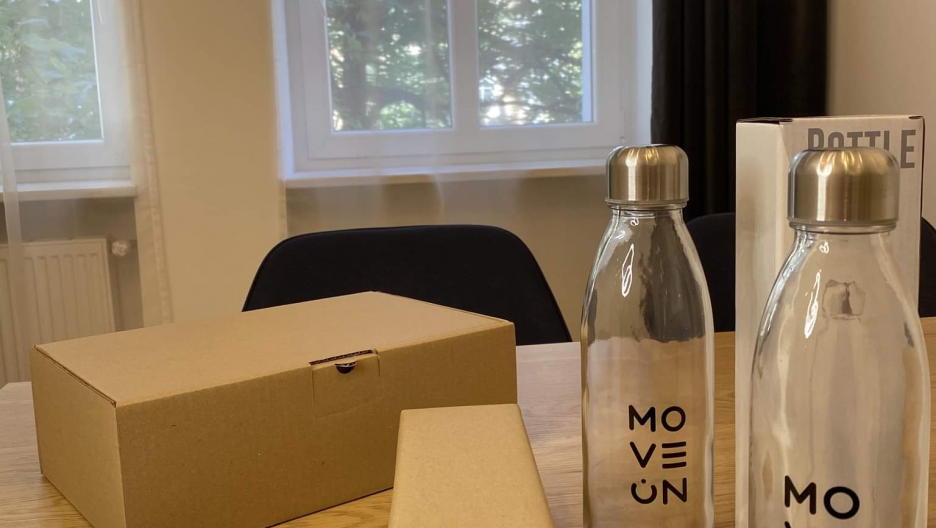 Szklana butelka reklamowa z nadrukiem logo dla szkoły językowej Move On